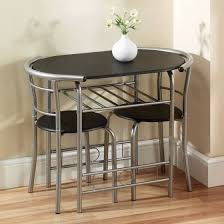 The table features two drop leaves that lift to extend the table to 42 inches in diameter; 2 Seater Dining Table Small Table And Chairs Small Kitchen Tables Space Saving Dining Table