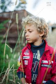 Curly haired little boy playing in sand at beach. Young Boy With Blonde Curly Hair Picking Berries Stock Photo Offset