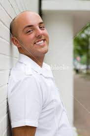 A young person with a relaxed pose leaning against a brick wall.  Royalty-Free Stock Image
