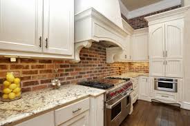 brick backsplash with white cabinets