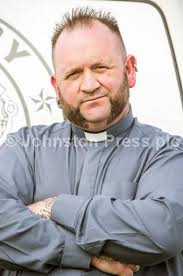 23459417-Mrs Elizabeth Methven lifts up a young customer to show her a  torpedo fish which was landed at Granton by the Kelso Paton
