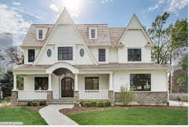 A chandelier sparkles over a concrete garden table. White House With Stone Home Builders White House With Stone House Exterior