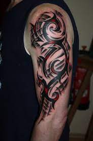 A black and red coloured tattoo which incorporates both traditional tribal elements and more modern three dimensional design. Black Red Tribal Tattoo Tribal Arm Tattoos For Men Tribal Tattoos For Men Tribal Arm Tattoos