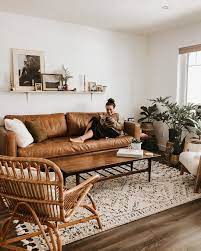 A moody boho living room with boho textiles, a glass coffee table, bold upholstery and a unique carved embellished asian door. Brown Leather Couch Modern Boho Living Room Living Room Decor Apartment Home Living Room Leather Couches Living Room