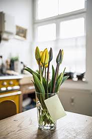 It takes only a few minutes to do and you can use any glass jar or containers you already have. Adhesive Note Gluing At Glass With Tulips On A Kitchen Table Stockphoto