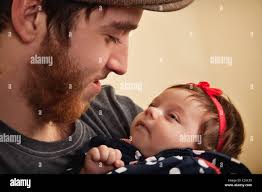 an infant girl looks up at her daddy Stock Photo