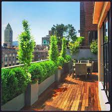 This Manhattan Rooftop Garden Design Features A Wood Deck And Wicker Furniture With Plantings Of Boxwood H Rooftop Design Rooftop Terrace Design Backyard Decor