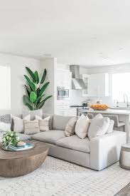 Stone Gray Low Sectional Sofa Paired With A Round Wood Coffee Table Atop A Cream Moroccan Ru Modern White Living Room White Living Room Decor Livingroom Layout
