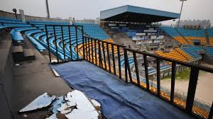 A man walks past a board with logos of the 2022 winter olympic games in beijing, china. Ten Years After Beijing S Triumphant Olympic Games Many Venues Lie Abandoned Rotting And Forgotten The Independent The Independent