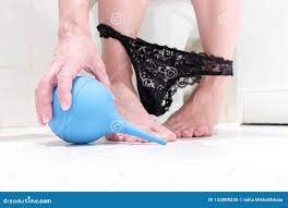 Cropped Legs of a Woman, Sitting on a Toilet with Lowered Panties and Blue  Cleansing Enema in Her Hand. Concept Image of Digestive Stock Photo - Image  of paper, dietary: 133808230