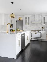 Stunning Kitchen Featuring A White Quartz Waterfall Island With White Shaker Cabinets Brass Hardware White Shaker Kitchen White Modern Kitchen Shaker Cabinets