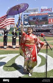 Japanese opera singer Asako Tamura in kimono costume sings the United  States national anthem at an exhibition baseball game between the  Washington Nationals and the New York Yankees at Nationals Park in