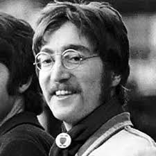 John Lennon and his Rolleiflex camera in his attic, June 1967. His button  says "Still Love the Beatles".