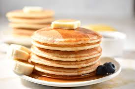 Fluffy pancake batter cooking on a hot buttered griddle with bubbles forming on the surface - a key step in the perfect pancake recipe