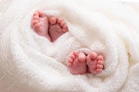 I gemelli sono neonati. una foto ravvicinata delle gambe dei gemelli appena  nati su un plaid bianco. piedi e dita di un neonato in una morbida coperta  bianca. foto di alta qualità | Foto Premium