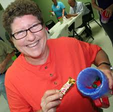 Becky Burt, facilities director at Eureka Springs Hospital, shows off some  of the treats all employees found in candy-filled mugs presented Monday by  the hospital, where employees toasted the Eureka Springs Hospital