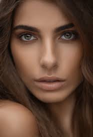 A close up of a woman with long hair and blue eyes