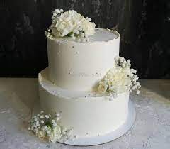 Chic glittery gold two tier wedding cake topped with blush flowers. Photo Of A Two Tier Engagement Cake With Flowers