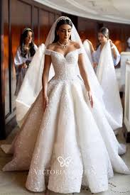 A ball gown wedding dress features a fitted bodice paired with a wide and full skirt. Modern Off Shoulder Lace Fall Ball Gown Wedding Dress Vq