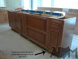 Once the cabinets were in place, the faces of the base cabinets were screwed together to keep them aligned, and the hanging cabinets were installed over them. Installing Kitchen Island Cabinets