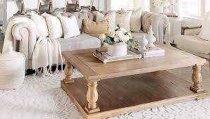 Brown oak coffee table sits in front of a light gray sofa accented with blue pillows. No Living Room Is Complete Without These Coffee Tables Liketoknowit
