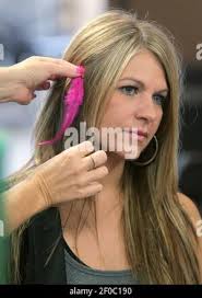 Shelly Talbot positions a feather in the hair of Tracey Gregory