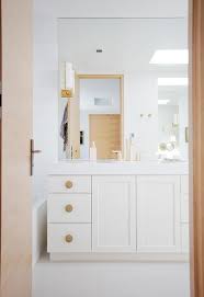 This master renovation designed by altereco showcases a stunning light wood vanity cabinet topped with a square vessel sink. Off White Washstand With Large Round Hammered Gold Knobs Transitional Bathroom