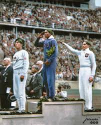 U.S. athlete Jesse Owens salutes during the presentation of his gold medal for the long jump, after defeating Nazi Germany's Lutz Long, during the 1936 Summer Olympics in Berlin. : r/ColorizedHistory