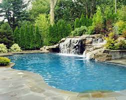This positioning provides the homeowner with a set of landscape enhancing features: Pool With Large Waterfall Backyard Pool Landscaping Pool Landscaping Pool Waterfall