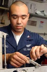 Aviation Ordnanceman 3rd Class Armando Lozano carefully places a wire