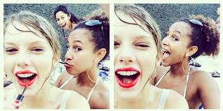 Taylor Swift applies red lipstick with her phone in selfie pictures