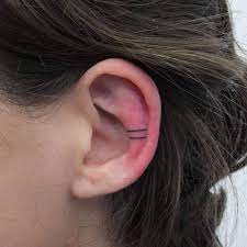 Two Tiny Lines Tattoo On The Left Ear Simple Wave Tattoo Line Tattoos Trendy Tattoos