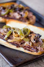 Savory beef, onions, peppers simmered in the crockpot, then topped on a hoagie with melted provolone! Easy Slow Cooker Philly Cheese Steak Sandwiches Dinner Then Dessert