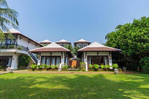 Phòng nghỉ tại Ancient Retreat Hoi An sử dụng nội thất gỗ, gam màu trung tính và ban công hướng vườn hoặc dòng sông yên bình.