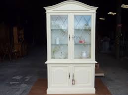 This traditional luxe kitchen features clean antique white raised panel cabinets with a glazed finish and vintage brass handles whose profiles match the ornate brass chandelier over the kitchen island. Vintage Glass Display Cabinet Painted Vintage Antique Farmhouse Furniture