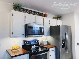 Use your kitchen cabinet tops as a space to stash things you have no room for elsewhere, like picnic baskets, decorative objects, or extra cutting boards. How To Decorate Above Kitchen Cabinets Jennifer Decorates