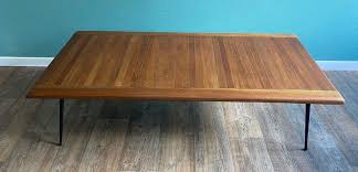 It showcases a long tabletop and a raised bottom shelf in paneled, solid pine wood with a gorgeous natural wood grain. Wooden Coffee Table With Black Lacquered Metal Legs 1970s For Sale At Pamono