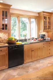 Accent colors include a deep brown range hood, black kitchen island, and deep grey marble countertops. 25 Light Wood Cabinets Ideas Kitchen Remodel Kitchen Design Home Kitchens