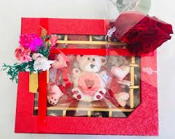 Valentines day hearts, candies, gift box and greeting card over wooden background. Cutie Pie Valentine Hamper Order Online Bangalore Valentine Gift Box
