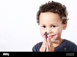 little boy praying to God with holy cross and being religious stock image  with hands held together praying in church