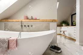 Modernes badezimmer mit flächenbündigen schrankfronten, weißen schränken, freistehender badewanne, bodengleicher dusche, grauen fliesen, weißer wandfarbe, aufsatzwaschbecken, grauem boden, offener dusche, einzelwaschbecken und schwebendem waschtisch in nürnberg. Freistehende Badewanne Mit Handtuchern In Grau Modernes Badezimmer Lizenzfreie Fotos Bilder Und Stock Fotografie Image 68444755