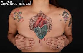 Tattoo burning heart with the name on the man's chest. Graphic Style Anatomical Heart Tattoo On The Chest