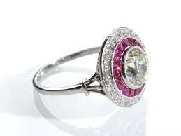 The ruby displays very good color, clarity and luster. Art Deco Style Diamond And Ruby Target Ring In Platinum