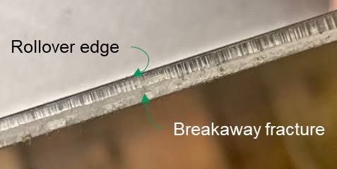 Magnified comparison of edge quality: laser cut (clean, slight heat-affected zone) vs punched (shear, fracture, rollover)