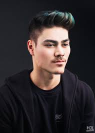 Pompadour cut with teal and blonde highlights