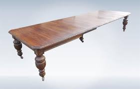 The retro extending dining table features a smooth oak veneer table top supported by sturdy solid oak tapered legs. 14ft Original Antique Oak Dining Table Seat 18 People
