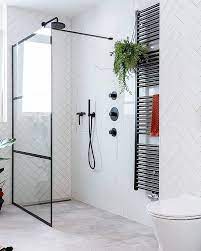 badkamerinspiratie inloopdouche met glazen douchewand en zwarte kranen zwarte verwarming op marmer marmerlook wan badkamer badkamer wandtegels lichte badkamer