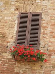 See 100 ideas for how to use old windows, glass paned or not, from decor to furniture. Red Flowers In Window Box On Brick Wall San Gimignano Italy Fake Window Decor Fake Window Brick Wall Decor