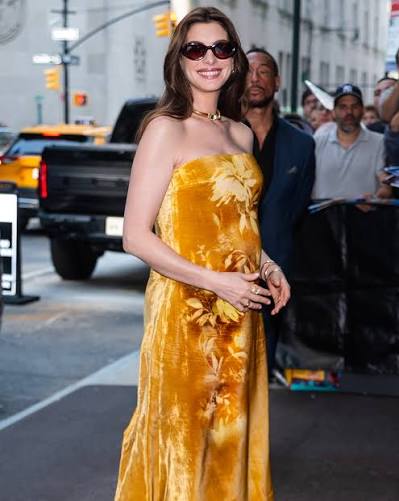 Anne Hathaway (@annehathaway) gives us another maternity style moment in New York City while promoting her upcoming film 'The Odyssey'. She steps out in a gold velvet tube dress by Lela Rose (@