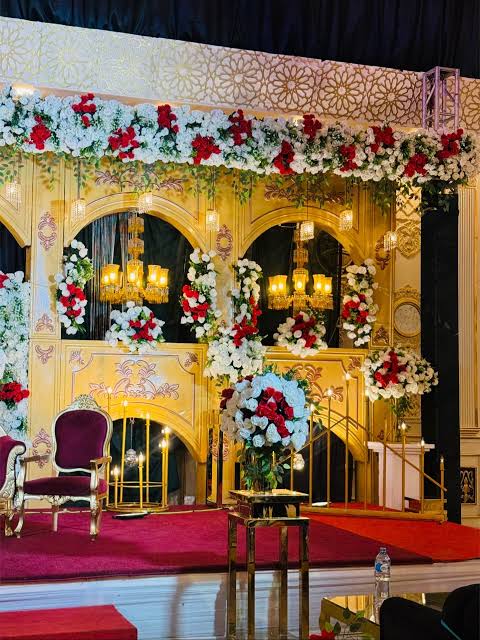 Royal gold arches paired with warm ambient lighting and rich red florals, AI generated